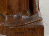a wooden statue of a woman holding a baby