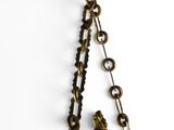 chain with a statue of a man and a woman hanging from it