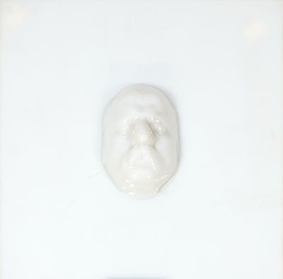 une photo d'un visage dessiné avec du dentifrice sur une surface blanche