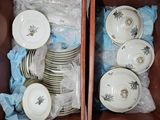 a lot of dishes and cups in a brown box