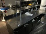 une grande cuisine avec des plans de travail et des appareils électroménagers en inox