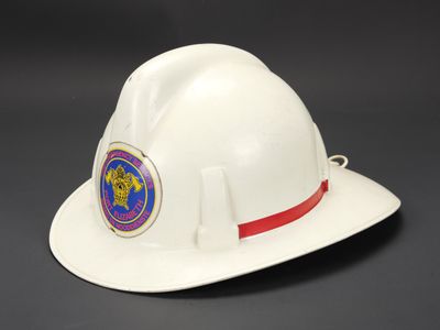 un gros plan d'un casque de pompier blanc sur fond noir