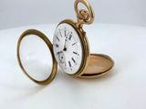 an antique pocket watch with a magnifying glass on a white surface