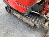 a red tractor that is parked on the side of the road