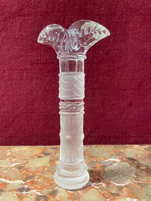 a glass vase on a table with a red background