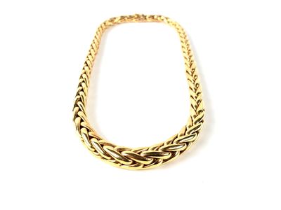 gros plan d'un collier en or sur fond blanc