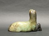 a statue of a duck laying down on the ground