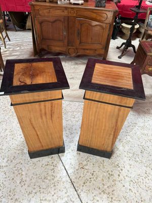 une paire de socles en bois avec des plateaux noirs dans un salon