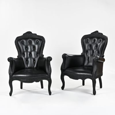 paire de fauteuils en cuir noir avec accoudoirs sculptés