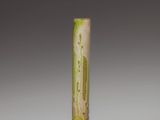 a yellow vase with a green design on it