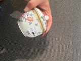 a person holding a tea cup on the floor