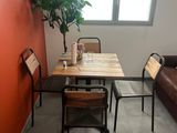 a table and chairs in a small room with a large window