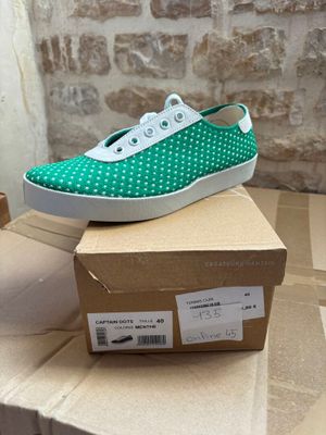 pair of green and white polka dot sneakers on top of a cardboard box
