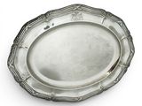 une assiette ovale en argent, ornée d'un motif décoratif sur le bord
