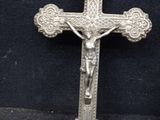 silver cross with a crucifix on a black background
