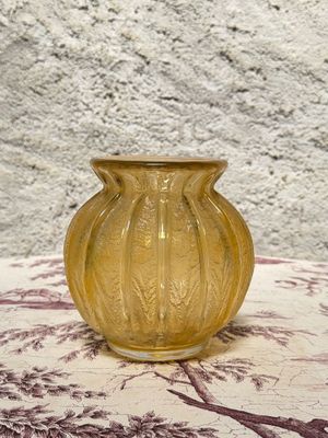 a yellow vase sitting on a table with a red and white table cloth