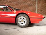 a red sports car parked in front of a brick wall