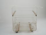 a clear plastic cart with two wheels on a white surface