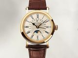 une montre-bracelet en or avec un bracelet en cuir marron