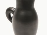 un vase noir avec une anse sur fond blanc