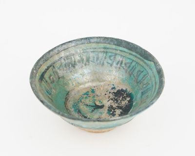 a green bowl with a black and white design on it