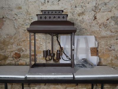 une lanterne posée sur une table devant un mur de pierre