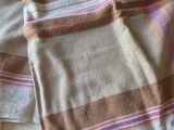 towels on a bed with a remote control on top of it