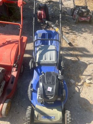 two lawn mowers that are parked next to each other