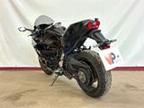 a black motorcycle parked in front of a white backdrop