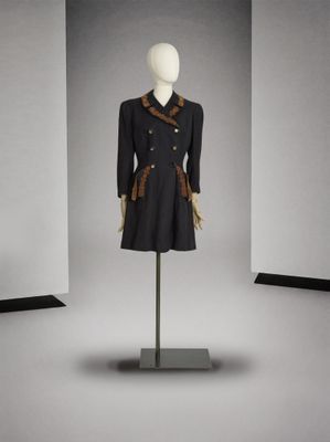 une photo d'un mannequin vêtu d'un manteau noir et d'une écharpe marron