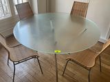 une table en verre entourée de chaises dans une pièce
