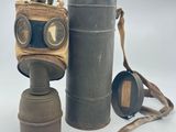 a gas mask that is sitting next to a canister