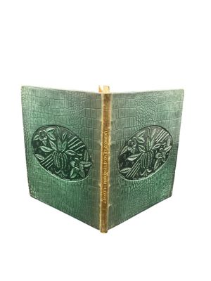 an old book with a green cover and a picture of a bird on it