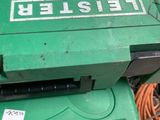 une boîte verte sur laquelle est posée une pancarte, posée par terre
