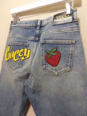 un gros plan sur un jean orné d'un écusson en forme de fraise à l'arrière