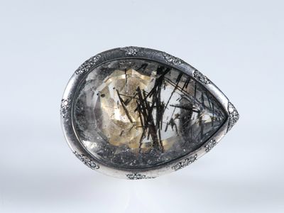 un gros plan d'une bague en argent sertie d'un quartz facetté