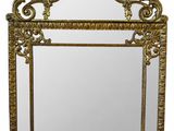 an ornate gold framed mirror with a bird and flower design