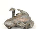 bronze figurine of a bird on a turtle on a white background