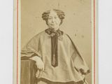an old photo of a woman wearing a cape