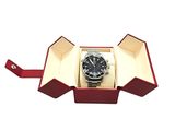 an open box with a watch inside of it on a white surface