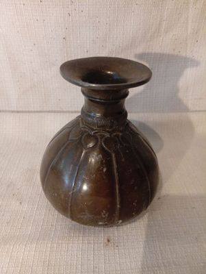 un vase marron posé sur un tissu blanc