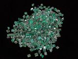 some pieces of green glass sitting on top of a black surface