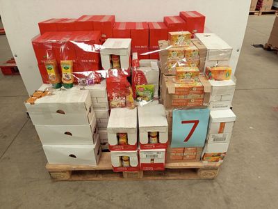 de nombreuses caisses de denrées alimentaires sur une palette dans un entrepôt