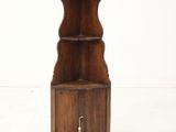 a small wooden shelf with a bell on it