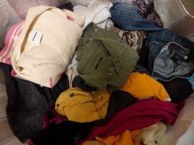 a pile of clothes in a basket on the floor