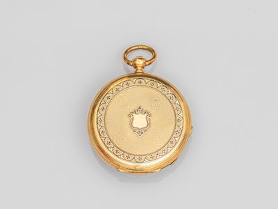 gros plan d'une montre de poche en or sur une surface blanche