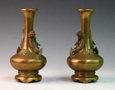 deux vases en bronze posés côte à côte sur une table