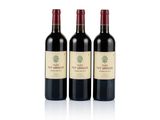 three bottles of red wine sitting next to each other on a white surface