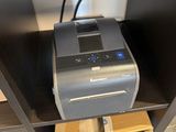 a printer that is sitting on top of a book shelf