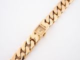 a close up of a gold bracelet on a white surface